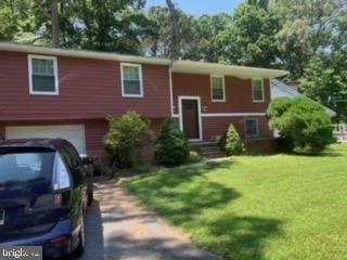 bi-level home with a front yard and a garage