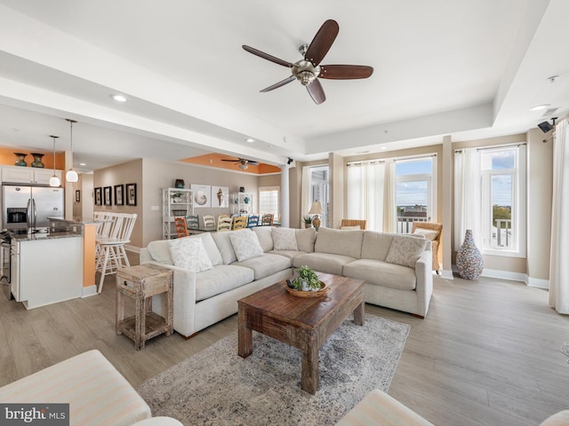 living room featuring ceiling fan and light hardwood / wood-style floors