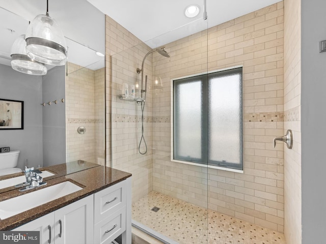 bathroom with tiled shower, toilet, and oversized vanity