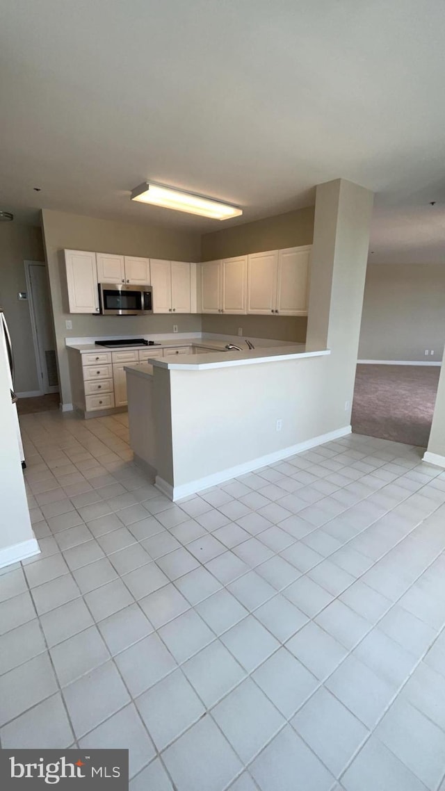 kitchen with white cabinets and light carpet