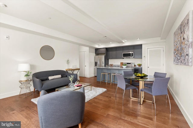 living room with dark wood-type flooring and beamed ceiling