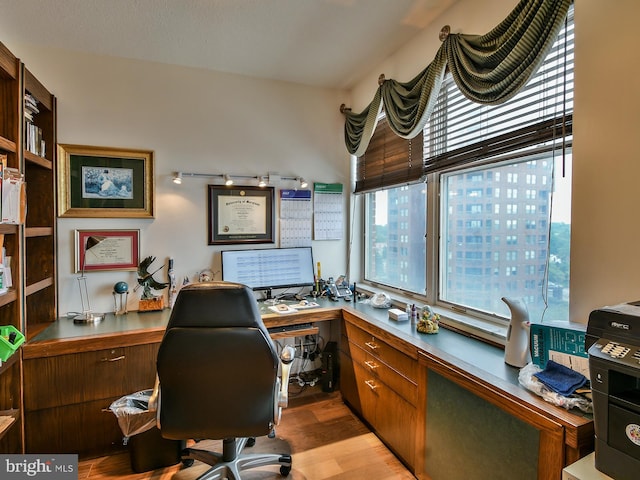 home office featuring light hardwood / wood-style floors and built in desk