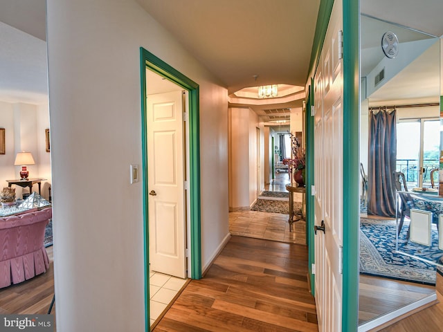 corridor with a chandelier and wood-type flooring