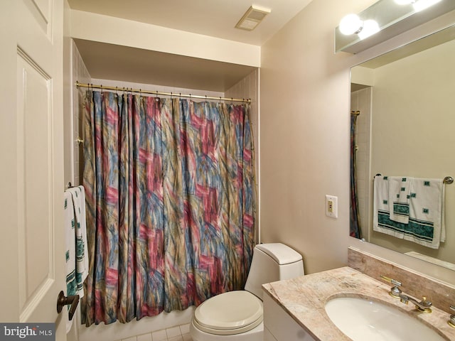 bathroom with toilet, vanity with extensive cabinet space, and tile flooring