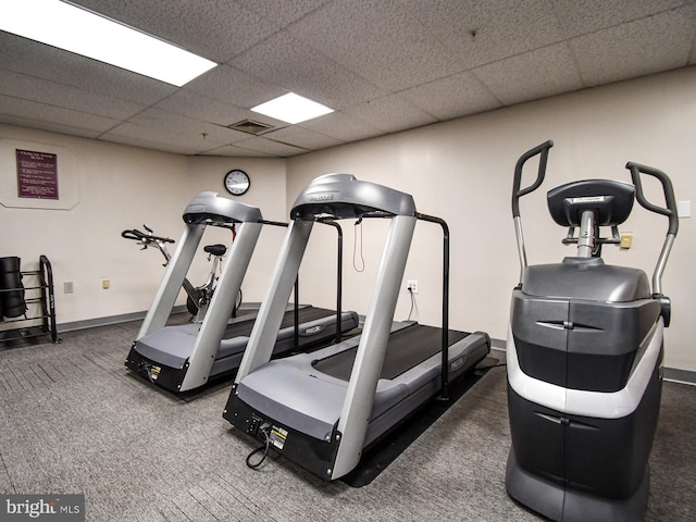 gym with a drop ceiling and dark colored carpet