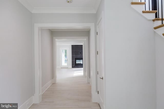 hall featuring ornamental molding and light hardwood / wood-style flooring