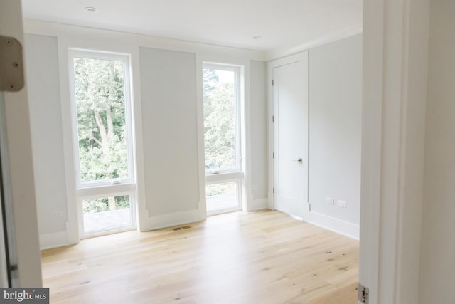 unfurnished room with plenty of natural light and light hardwood / wood-style floors