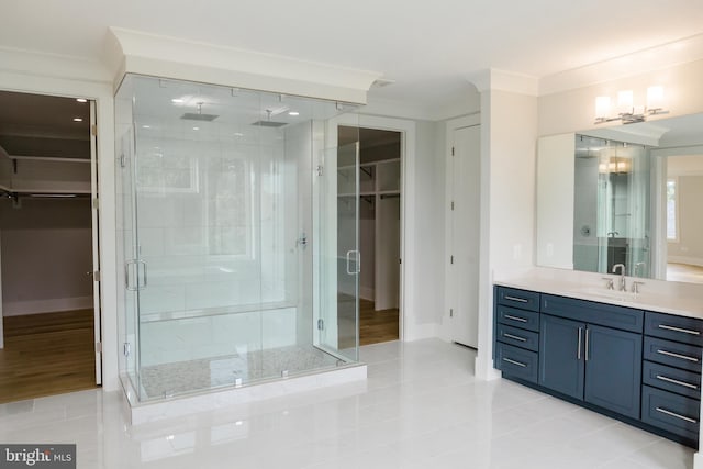 bathroom with a shower with shower door, vanity, ornamental molding, and tile floors