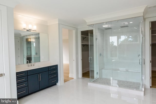 bathroom with hardwood / wood-style floors, a shower with shower door, and large vanity