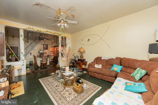 living room featuring ceiling fan and dark tile flooring