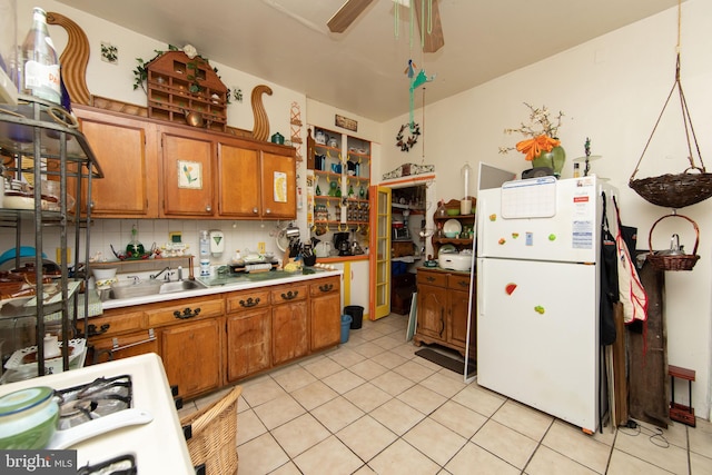 kitchen with backsplash, white fridge, ceiling fan, light tile flooring, and sink