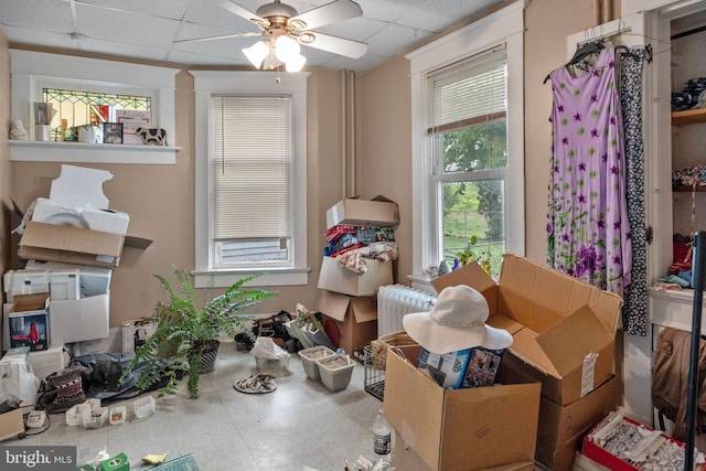 misc room with a paneled ceiling, light tile floors, ceiling fan, and a wealth of natural light