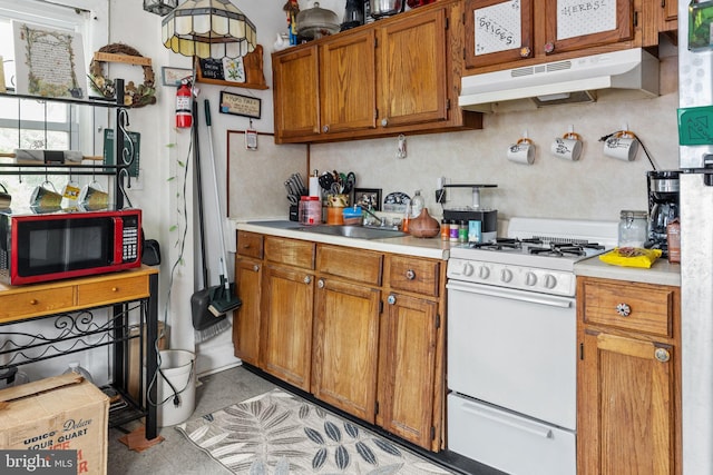 kitchen with white gas range and sink