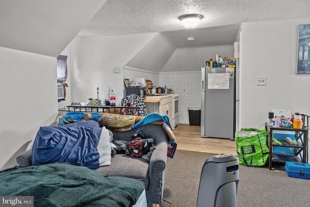 playroom with a textured ceiling, light carpet, and vaulted ceiling