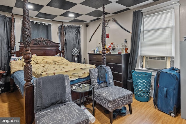 bedroom featuring a paneled ceiling and light wood-type flooring