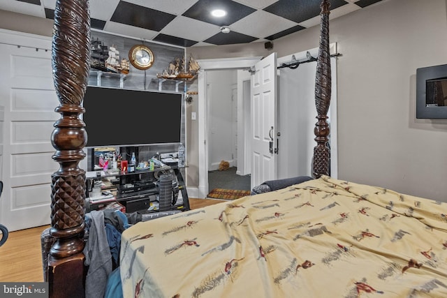 bedroom with hardwood / wood-style flooring and a paneled ceiling