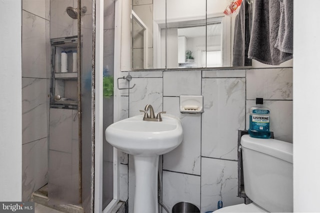 bathroom featuring tile walls, toilet, and tiled shower