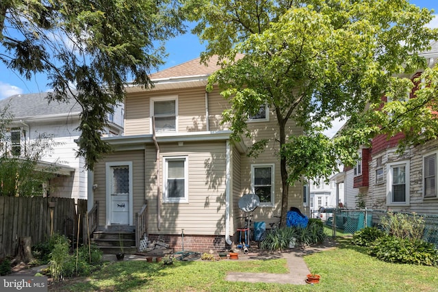 rear view of property featuring a yard