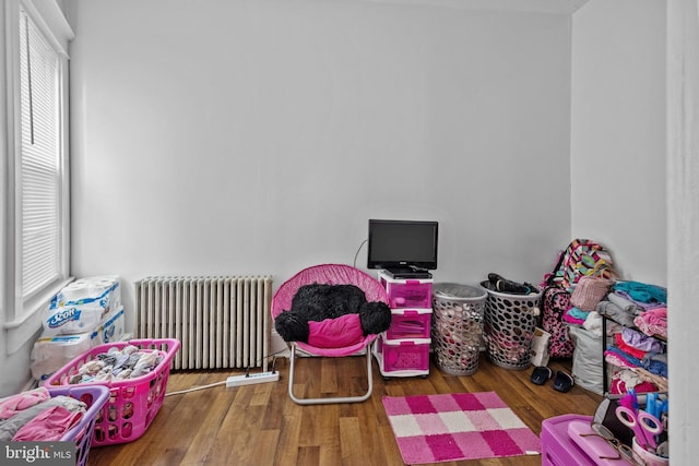 playroom with a healthy amount of sunlight, radiator, and dark hardwood / wood-style flooring