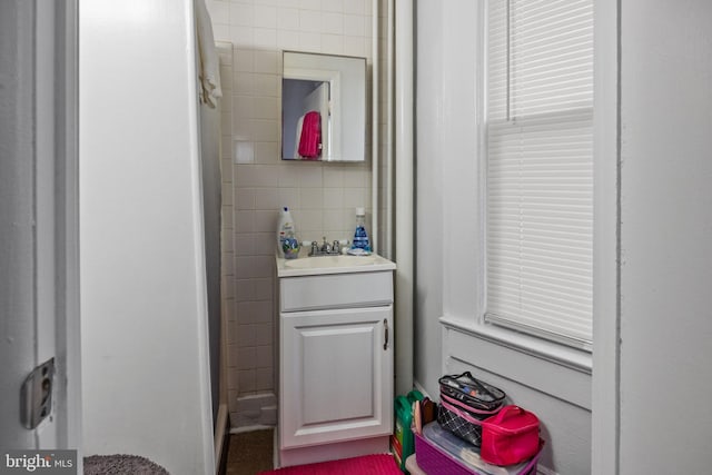 bathroom with tile walls, tasteful backsplash, and vanity with extensive cabinet space