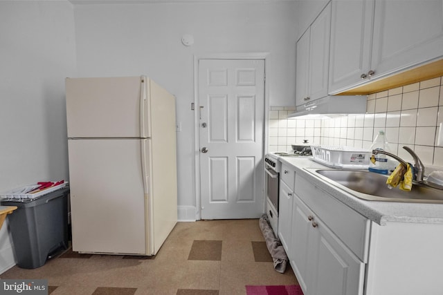 kitchen with light tile flooring, backsplash, white appliances, and white cabinetry