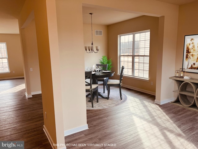 dining space with an inviting chandelier, hardwood / wood-style flooring, and a healthy amount of sunlight