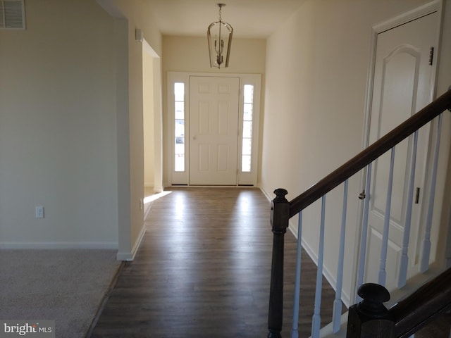 foyer featuring a notable chandelier and dark wood-type flooring