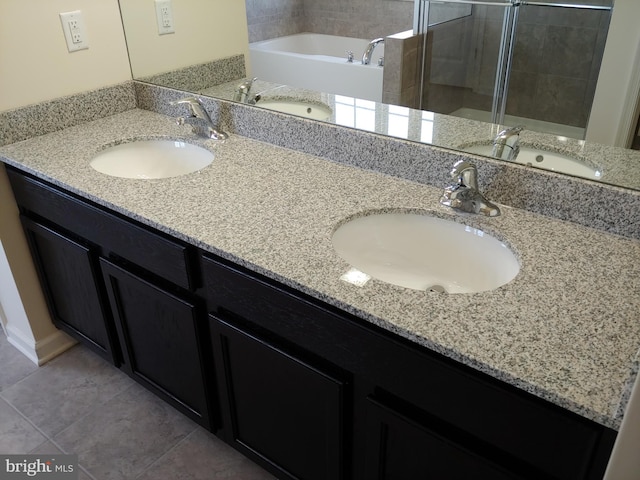 bathroom with a bathing tub, tile floors, and dual bowl vanity