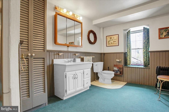 bathroom with radiator heating unit, toilet, and vanity