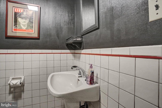 bathroom featuring tile walls and sink