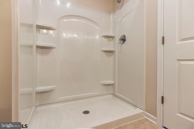 bathroom with a shower and tile flooring