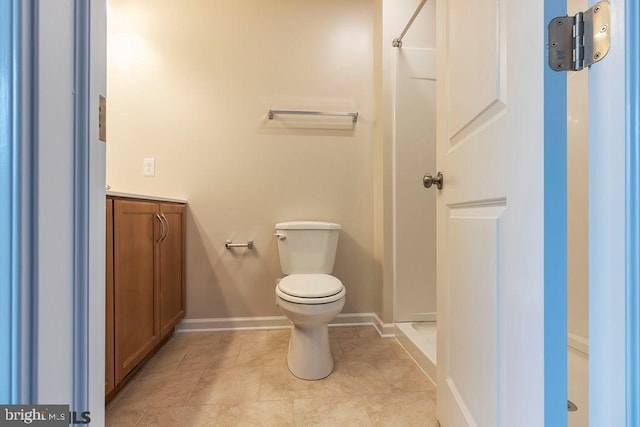 bathroom with tile floors, a shower, vanity, and toilet