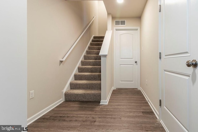 stairs featuring dark hardwood / wood-style floors