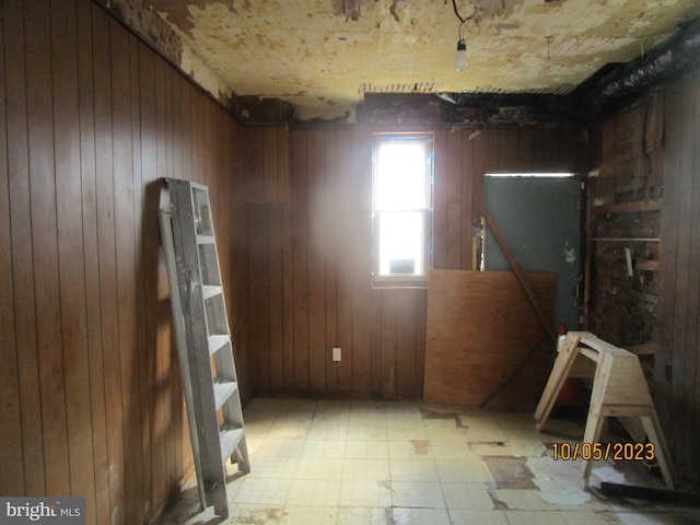 miscellaneous room with light tile floors and wood walls