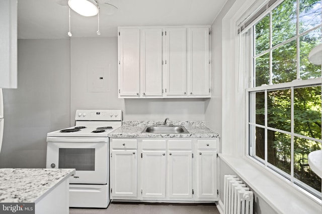 kitchen featuring white cabinets, electric stove, ceiling fan, and sink