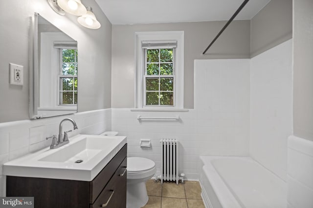 full bathroom with plenty of natural light, toilet, vanity with extensive cabinet space, and radiator