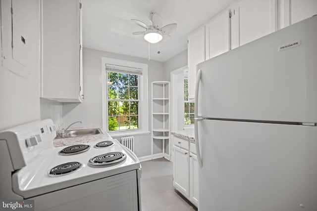 kitchen with white refrigerator, stove, ceiling fan, white cabinets, and sink