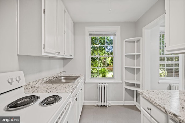 kitchen with radiator heating unit, white cabinets, stove, and sink