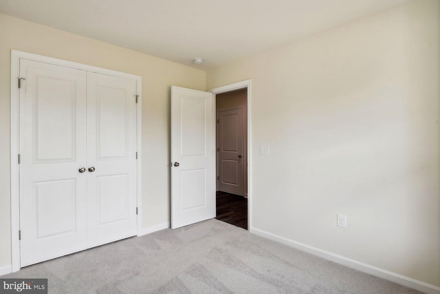 unfurnished bedroom with a closet and light carpet