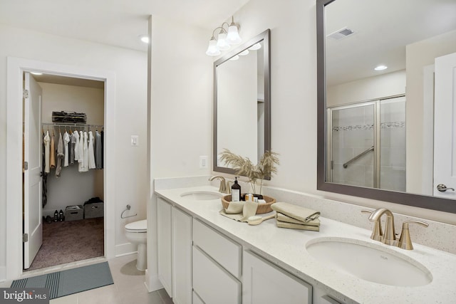 bathroom with tile flooring, toilet, an enclosed shower, and dual bowl vanity