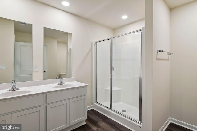 bathroom featuring an enclosed shower, vanity, wood-type flooring, and toilet