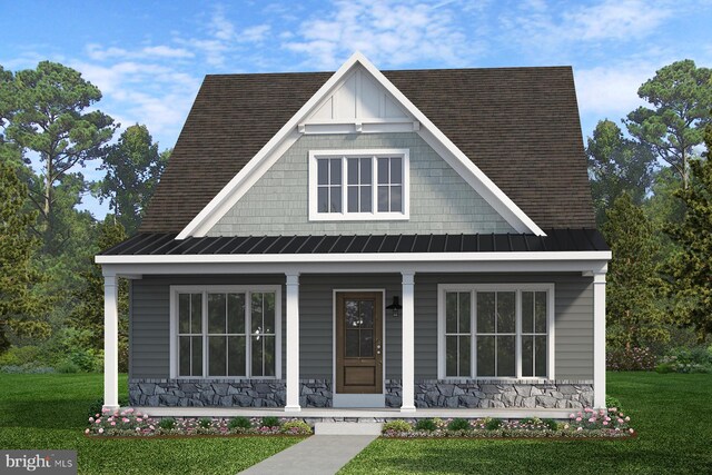 view of front of house with a standing seam roof, stone siding, covered porch, and a front yard