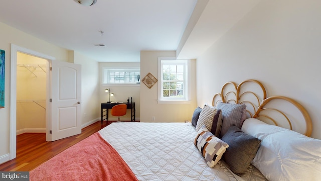 bedroom with a closet, light hardwood / wood-style floors, and a spacious closet