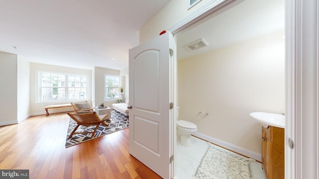 bathroom with hardwood / wood-style flooring, toilet, and vanity