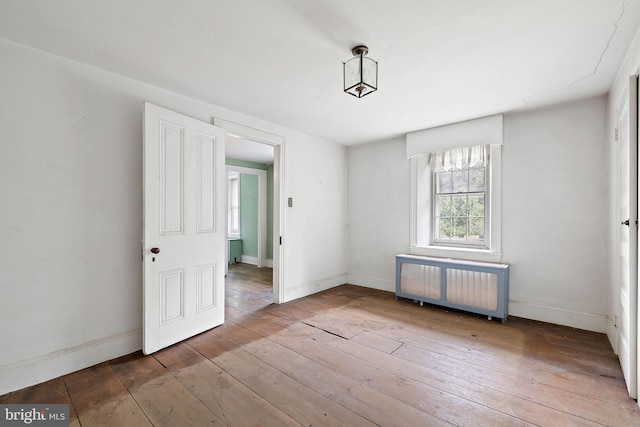 empty room featuring radiator and dark wood-type flooring