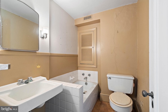 bathroom with toilet, a washtub, and sink