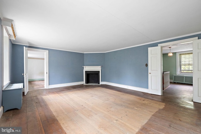 unfurnished room featuring radiator heating unit, ornamental molding, and dark wood-type flooring