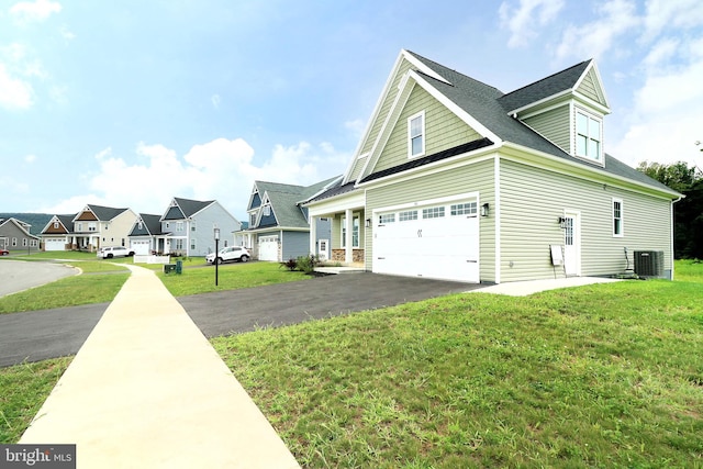 exterior space with a lawn, central AC, and a garage