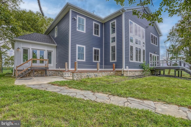 back of house featuring a wooden deck and a yard