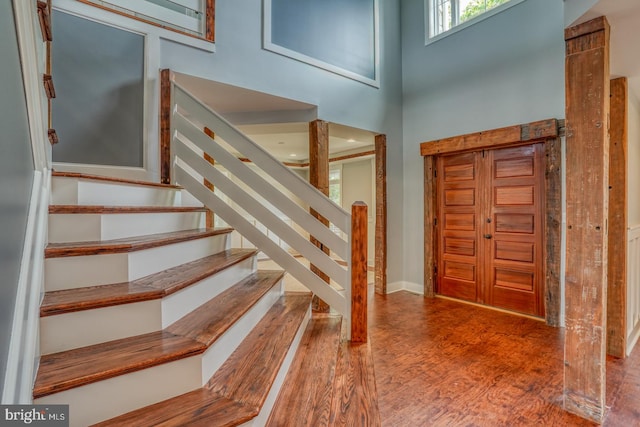 entryway featuring dark hardwood / wood-style flooring and a towering ceiling